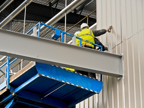 two construction workers fitting cladding