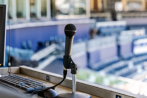 A microphone in a commentary booth at a sport stadium