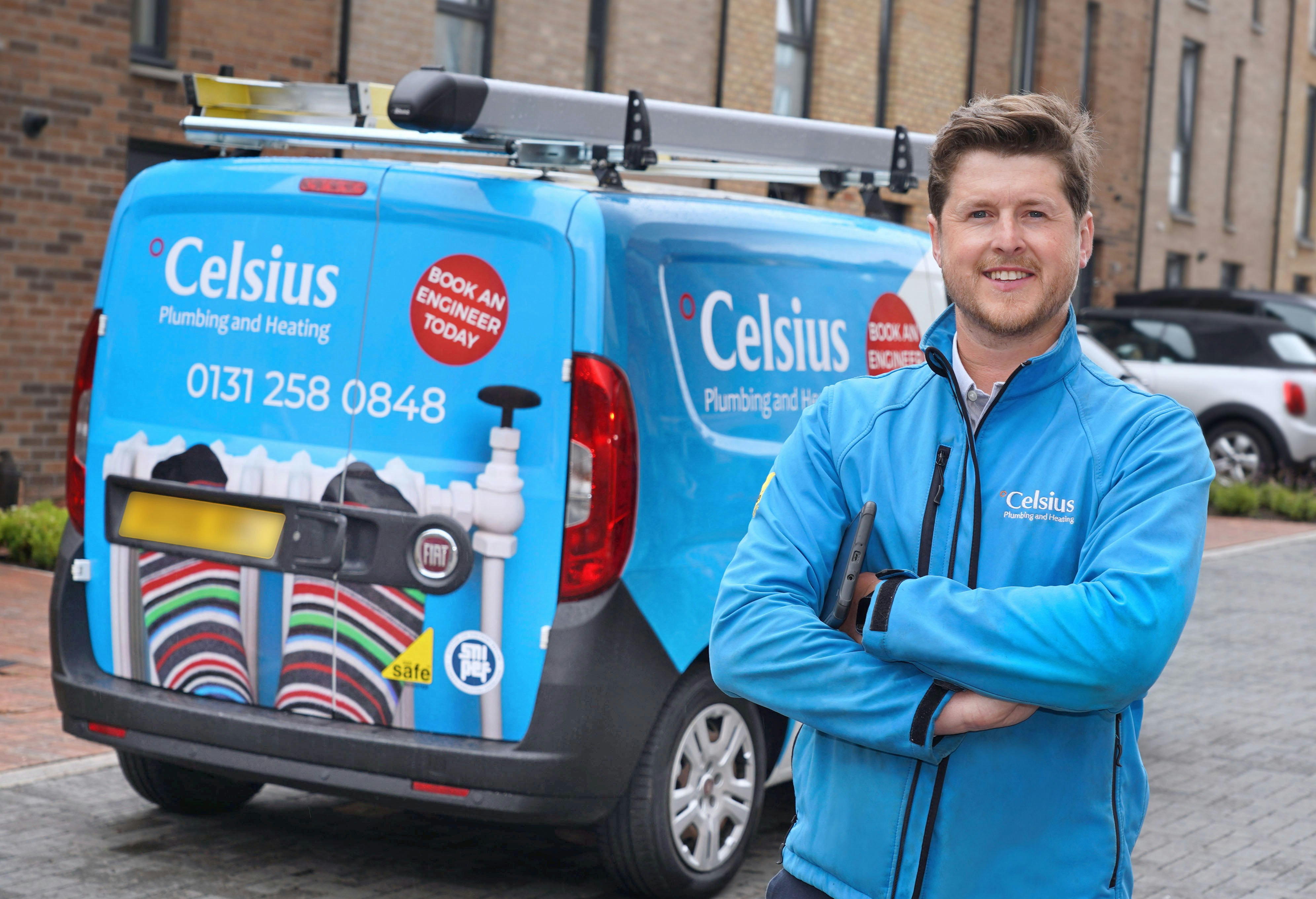 The image shows a man standing next to a blue van.