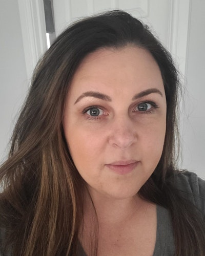 The image shows a woman with brown hair.