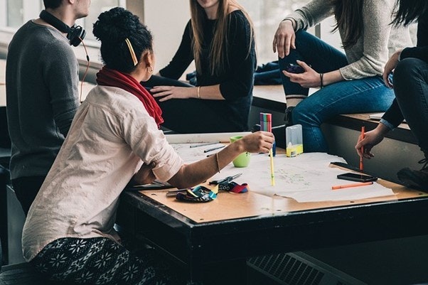 a group of people sat around a desk working