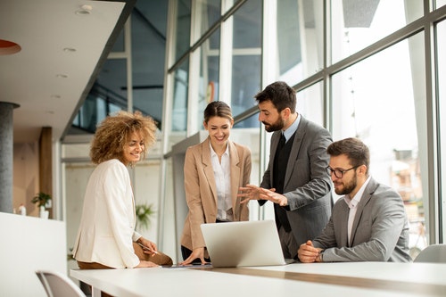 four people stood around a desk