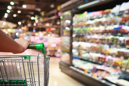 Someone pushing a trolley through a supermarket aisle