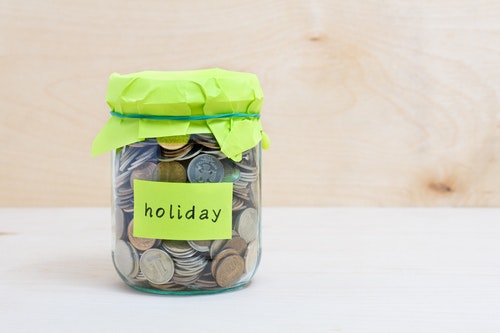 a jar of coins labelled holiday