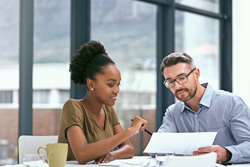 a male and female colleague working at a desk together