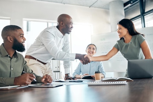 a man and a woman shaking hands at a desk