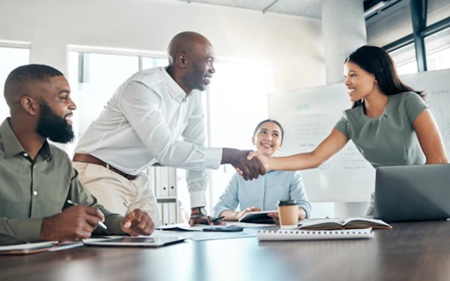 a man and a woman shaking hands at a desk