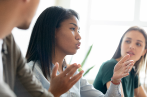 three employees in a meeting having a discussion.