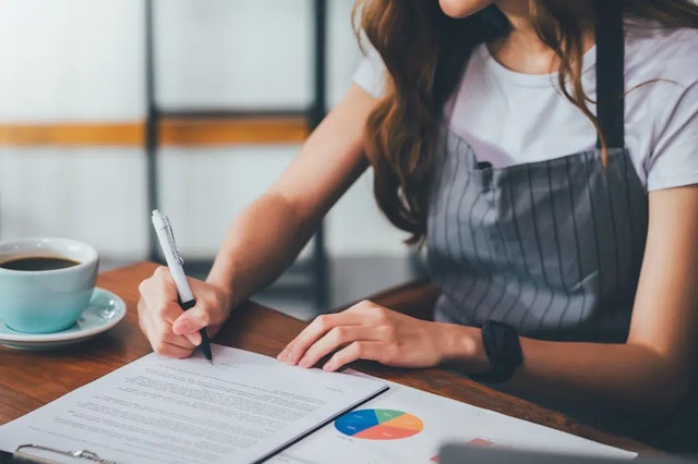 woman writing on notepad