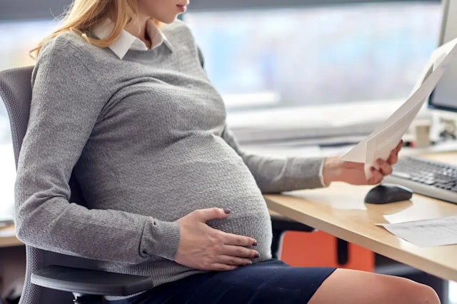 a pregnant woman at a desk