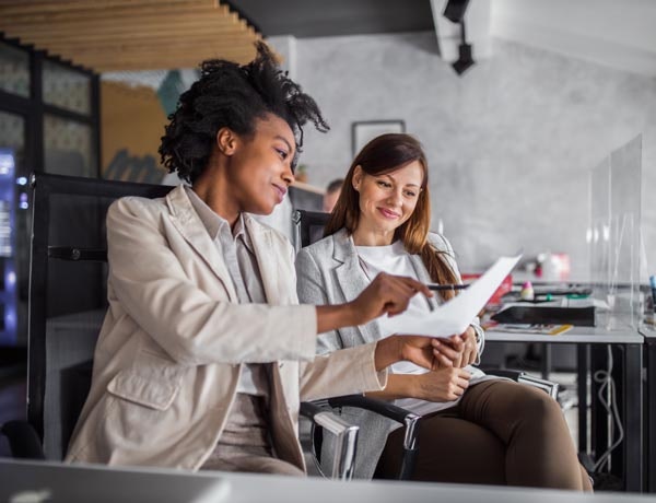 Two female employees looking at a document.