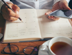 person writing in a calendar