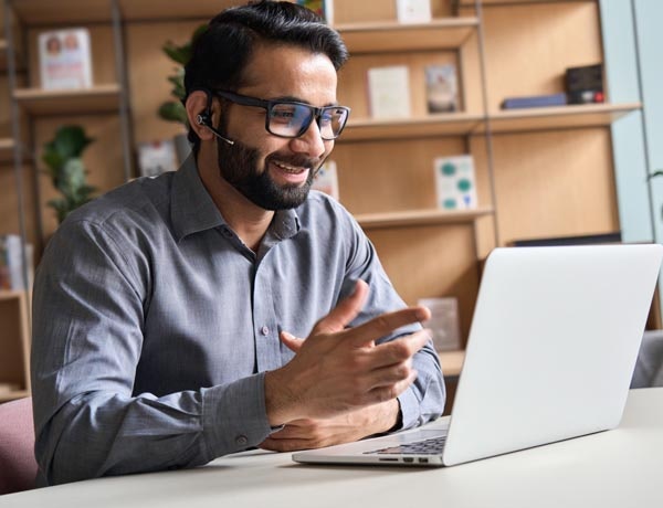 A man attends a video call on his laptop.