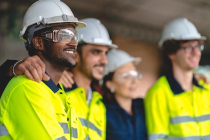 Workers smiling wearing PPE