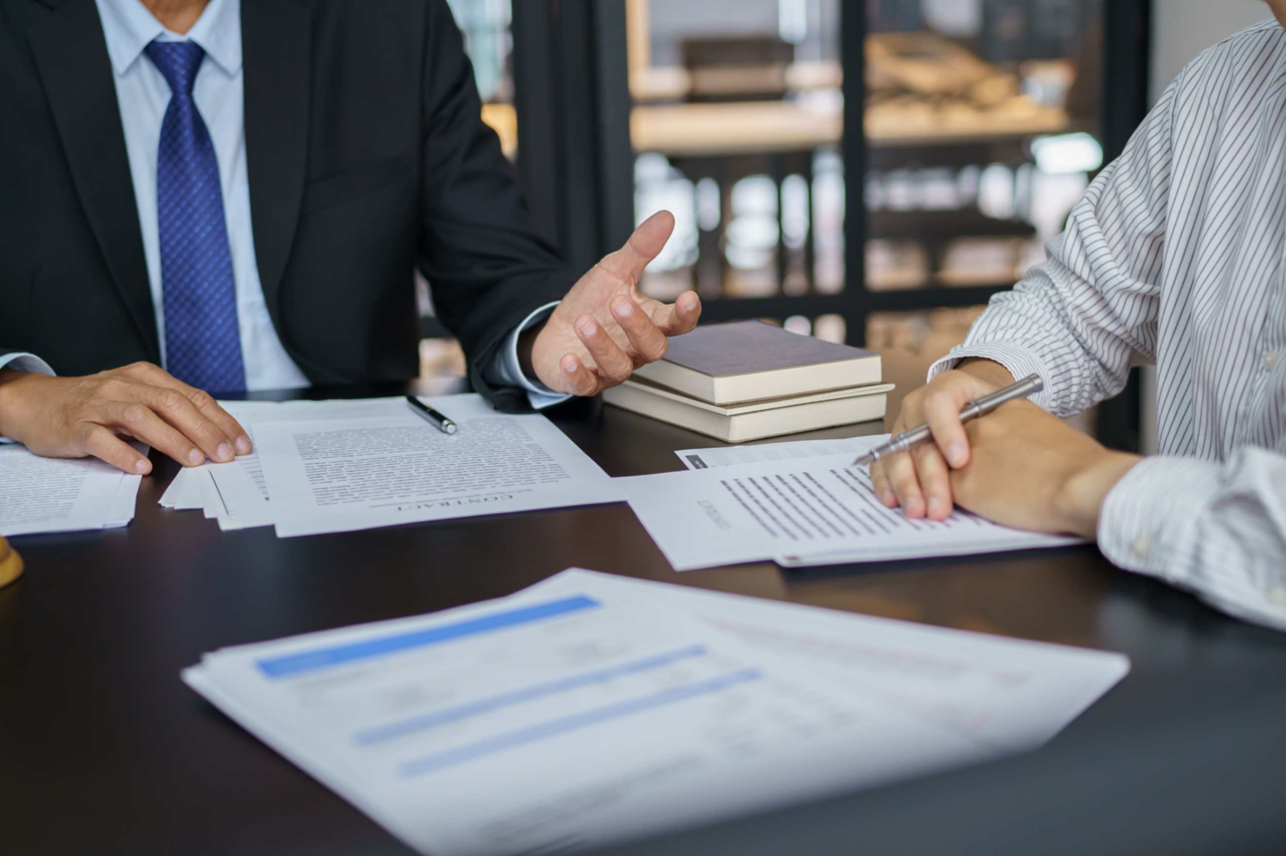 two men at a desk with paperwork