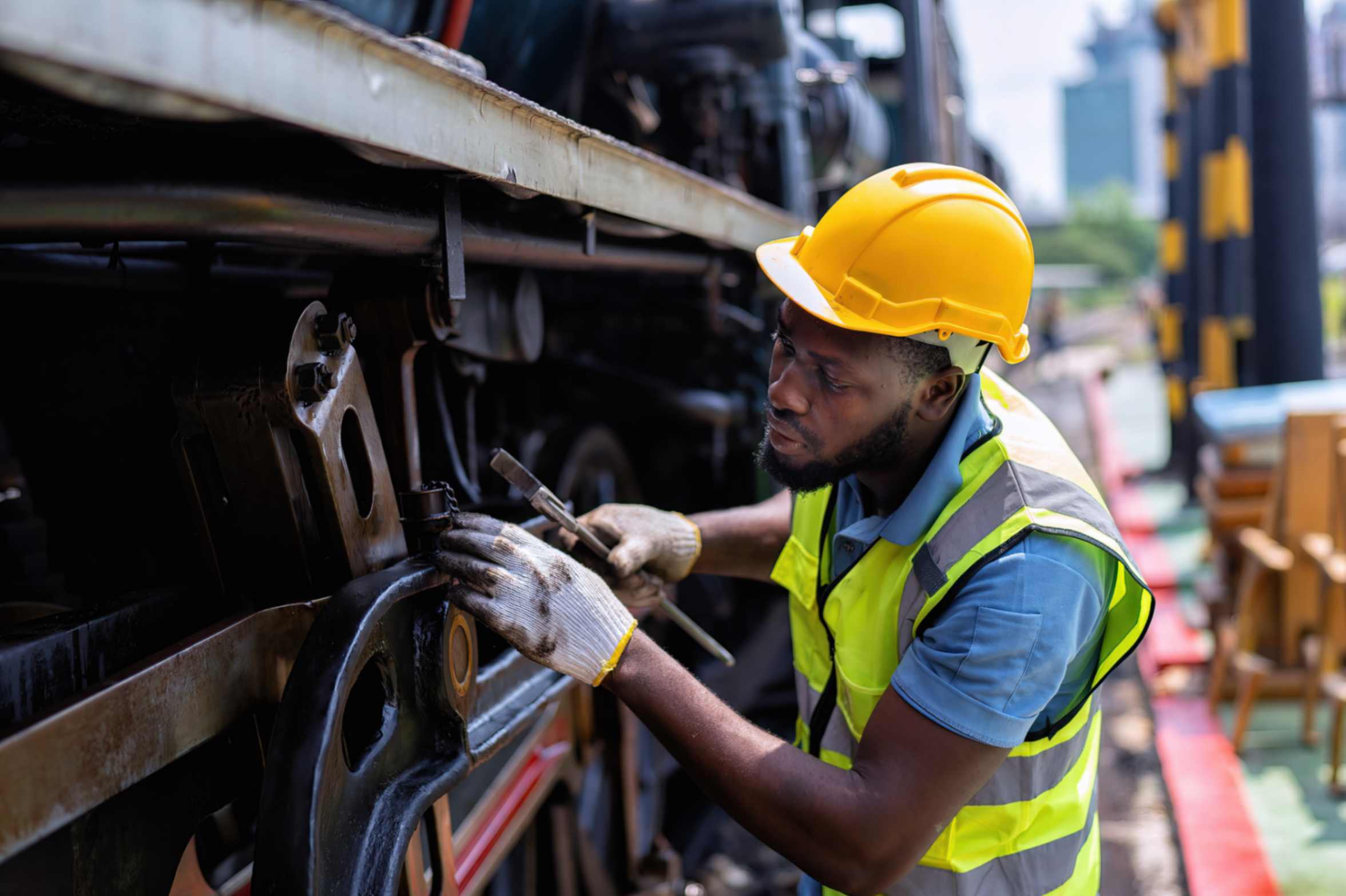 a man with a high vis vest and helmet working on a lorry
