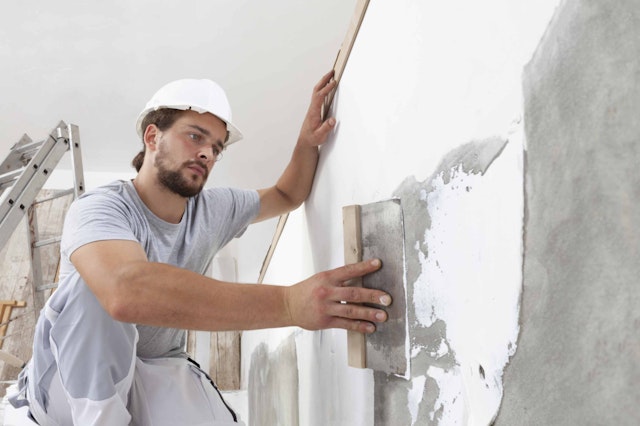 a man using painter tools on a wall
