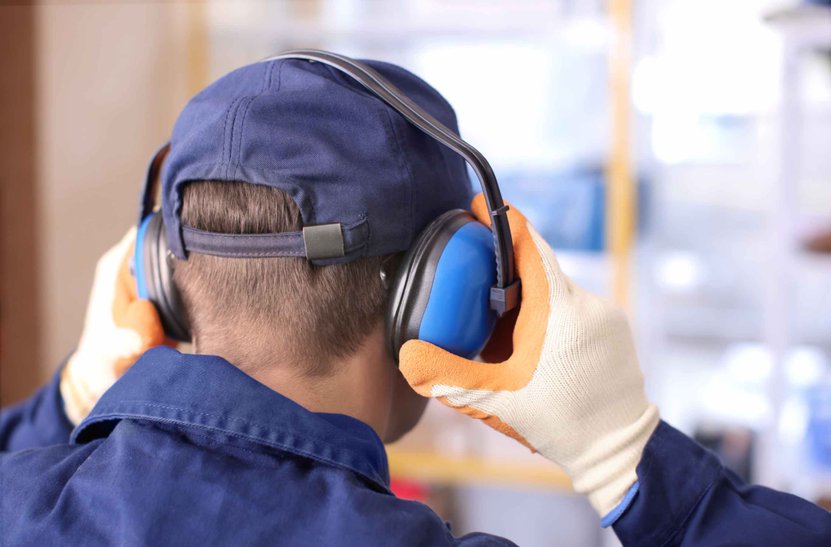 a man covering his ears with ear protectors