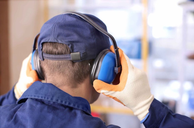 a man covering his ears with ear protectors