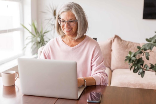 a middle aged woman working at her laptop at home