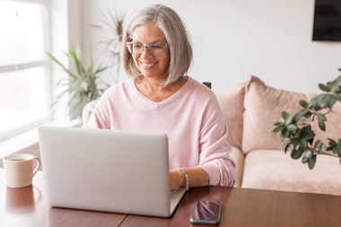 a middle aged woman working at her laptop at home