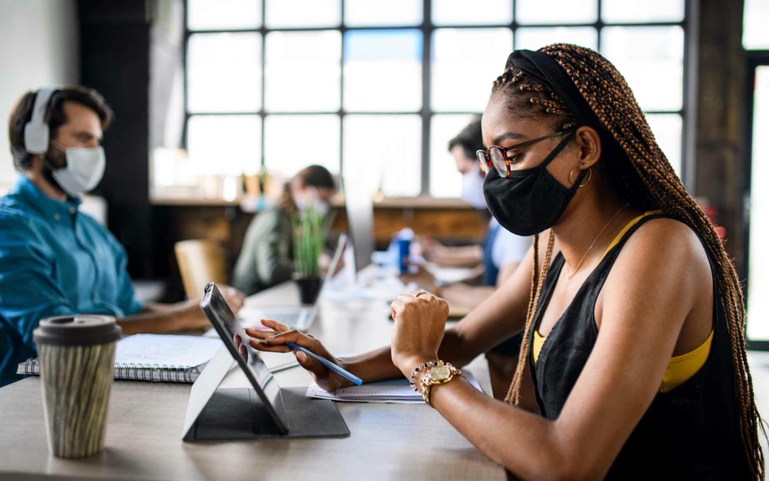 people at a desk wearing face masks