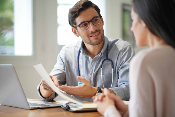 a male doctor talking to a female patient