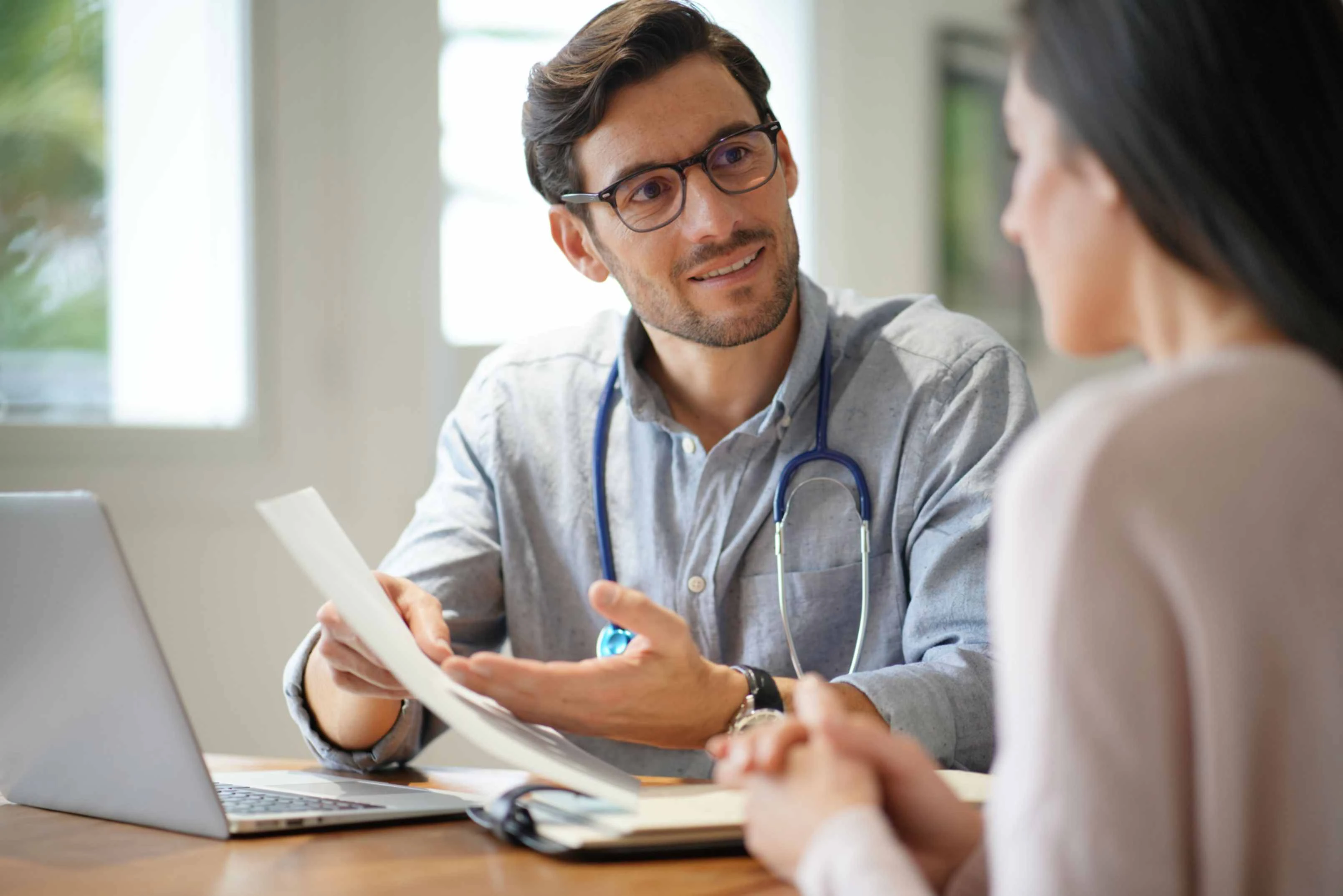 a male doctor talking to a female patient