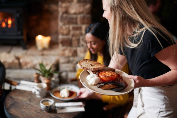 a woman serving food to a person