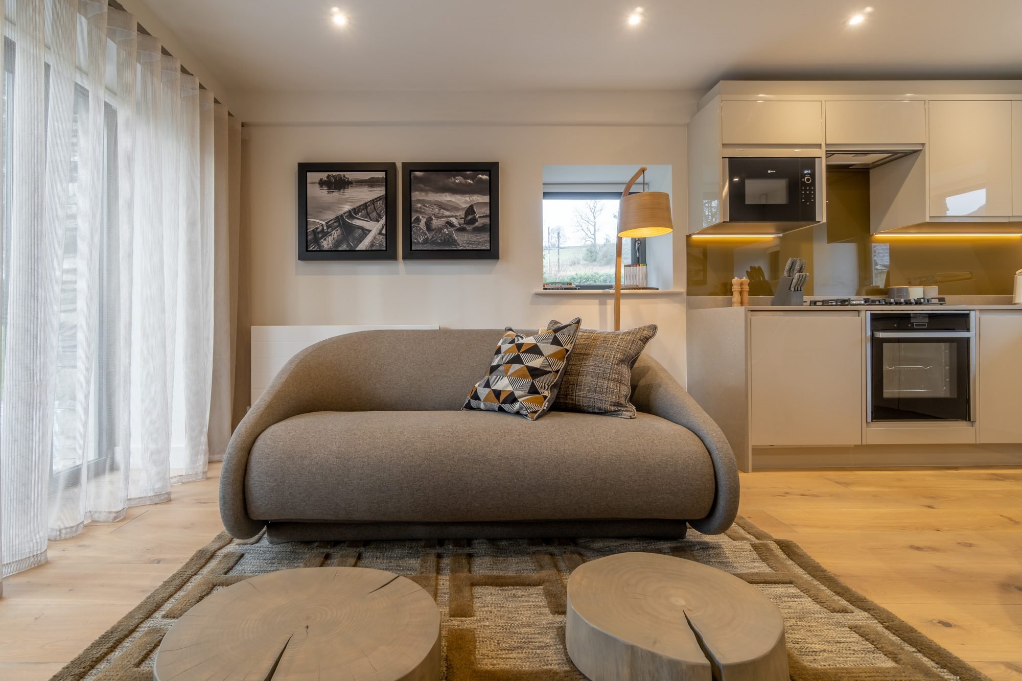 Kitchen and living room with brown couch.