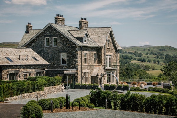A large property surrounded by hills and greenery.