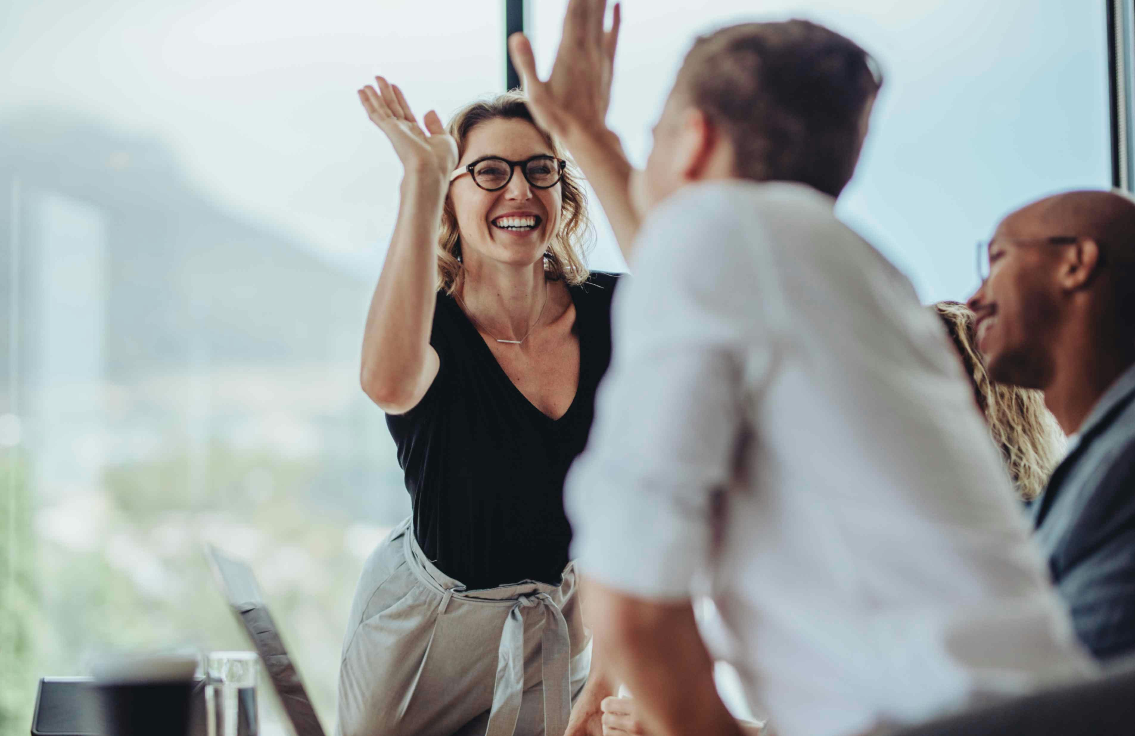 a woman and a man high fiving by a window