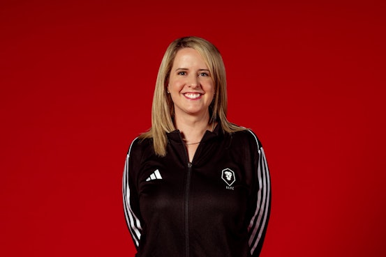 A woman with blonde hair and a black sports top.