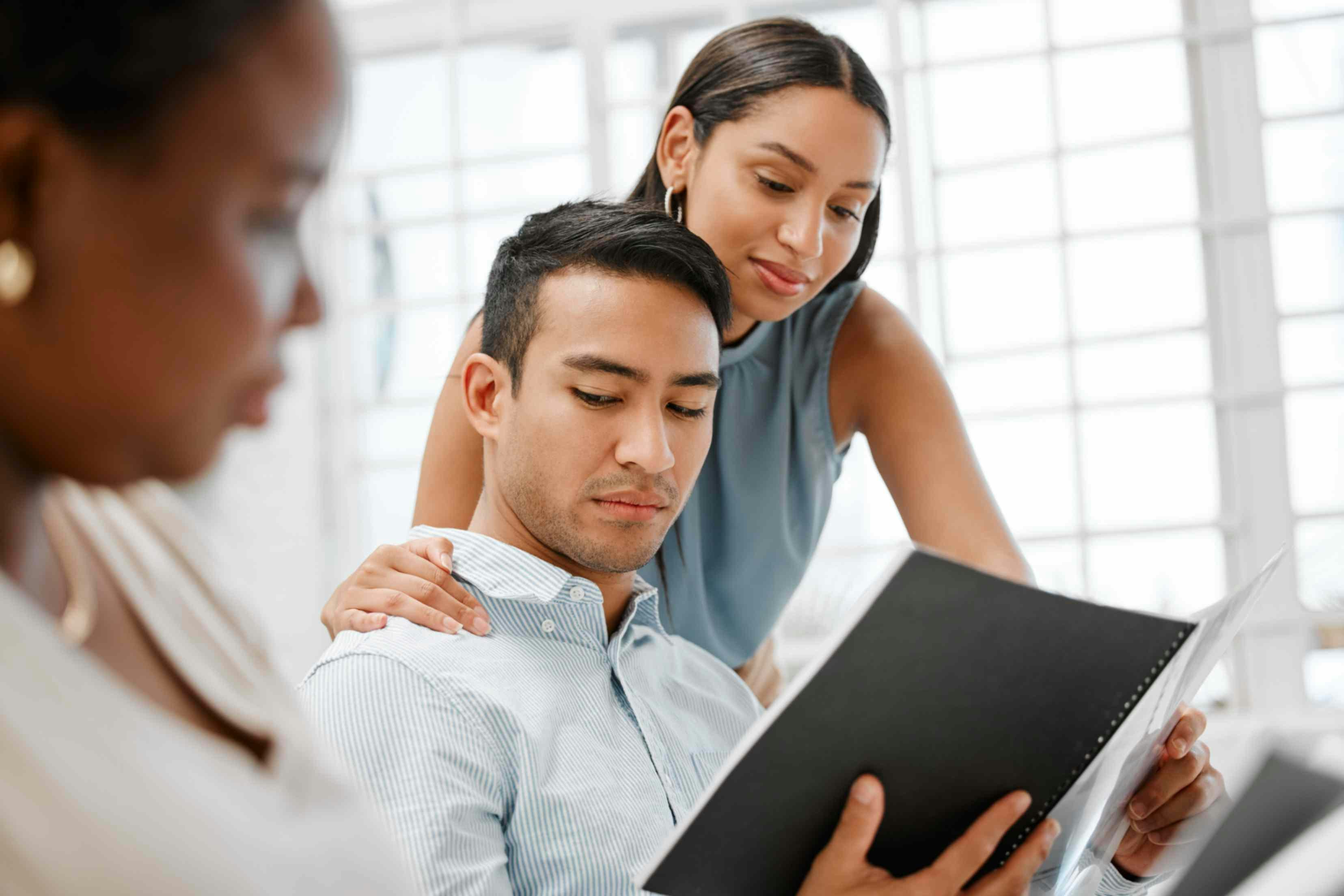 A woman puts her hand on a man's shoulder