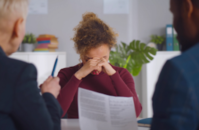 woman in meeting with head in hands