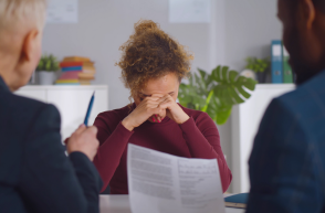 woman in meeting with head in hands