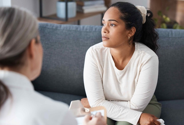 Thinking psychologist, therapy and woman in consultation for mental health on sofa