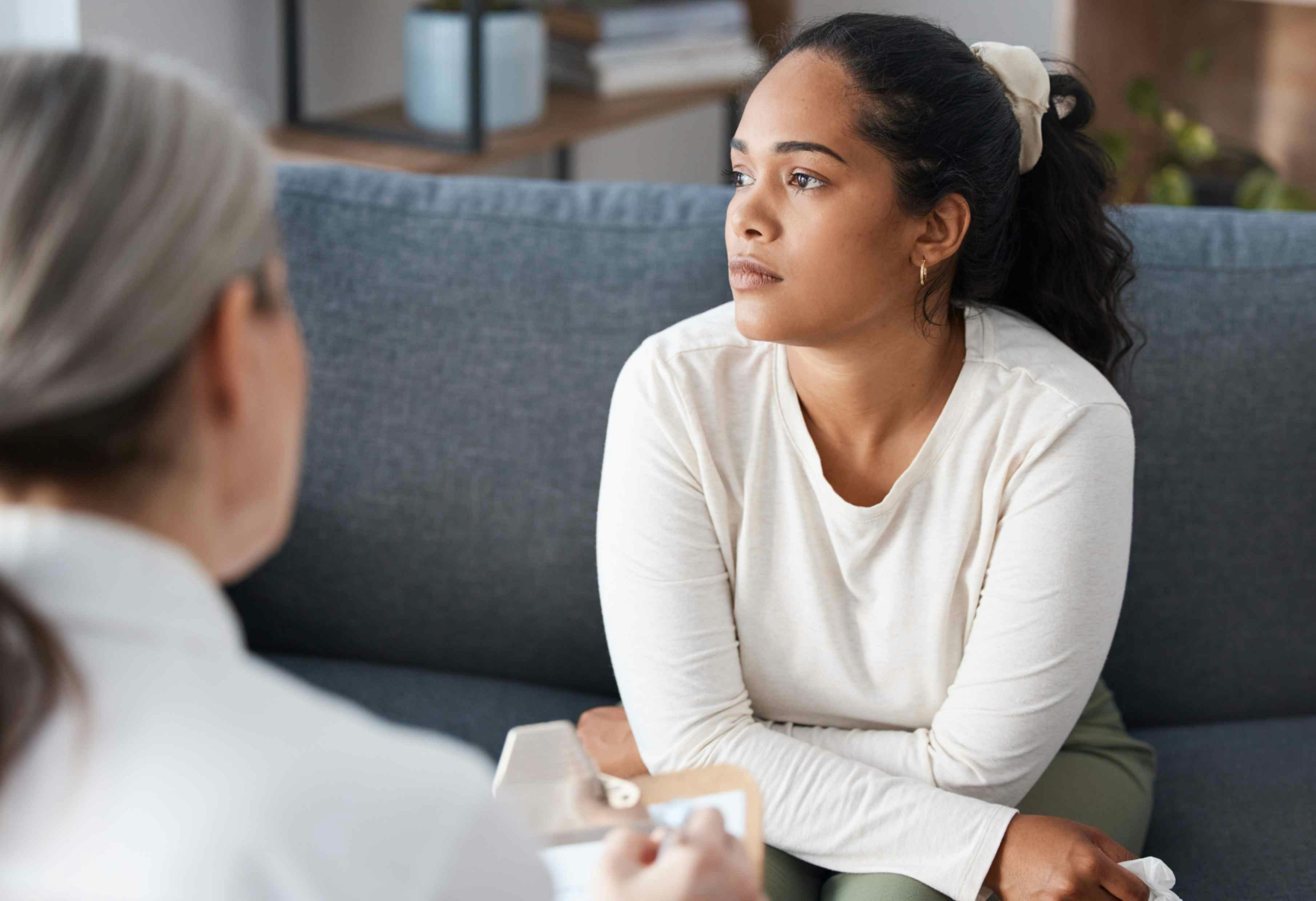 Thinking psychologist, therapy and woman in consultation for mental health on sofa