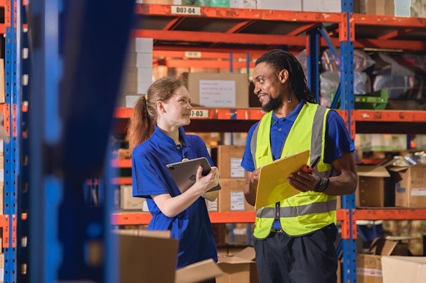 Two people having a conversation in a warehouse.