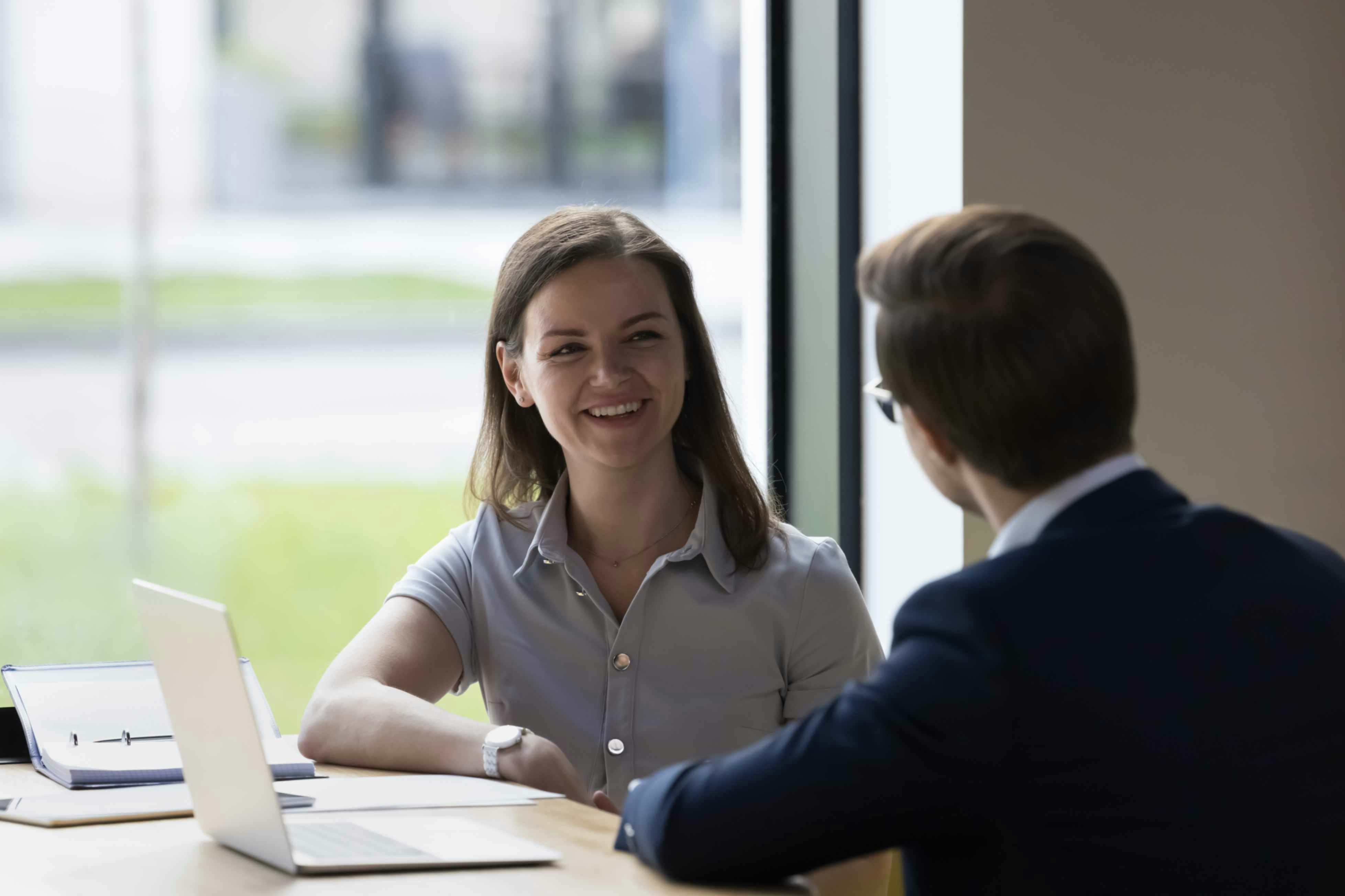 two people talking at a desk