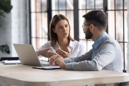 a woman talking to a man at a desk