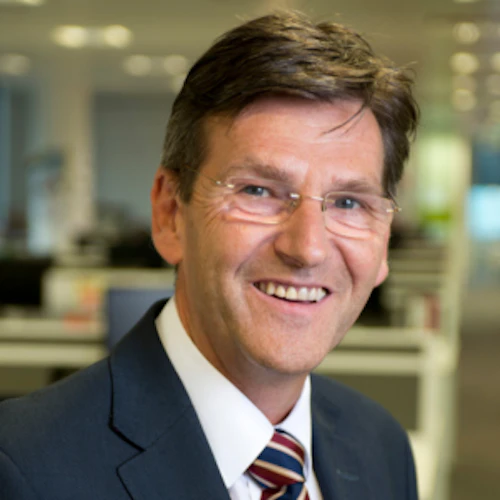 A smiling man wearing a suit.