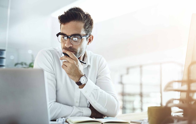 a man sat at a computer looking focused