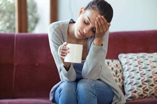 a woman holding a mug sitting on a couch