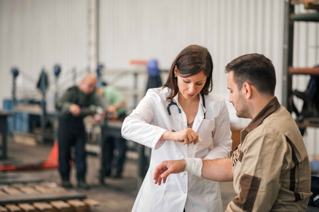 a doctor examining another worker in a warehouse