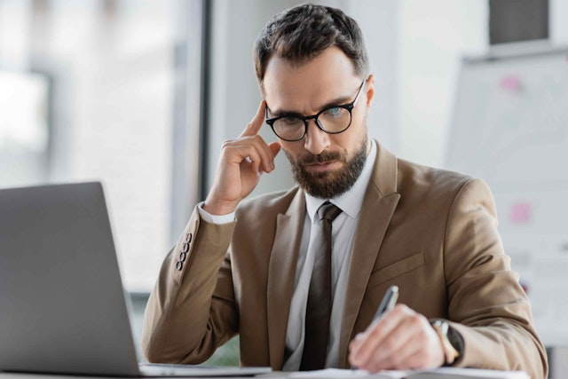 a man sat at a computer looking focused