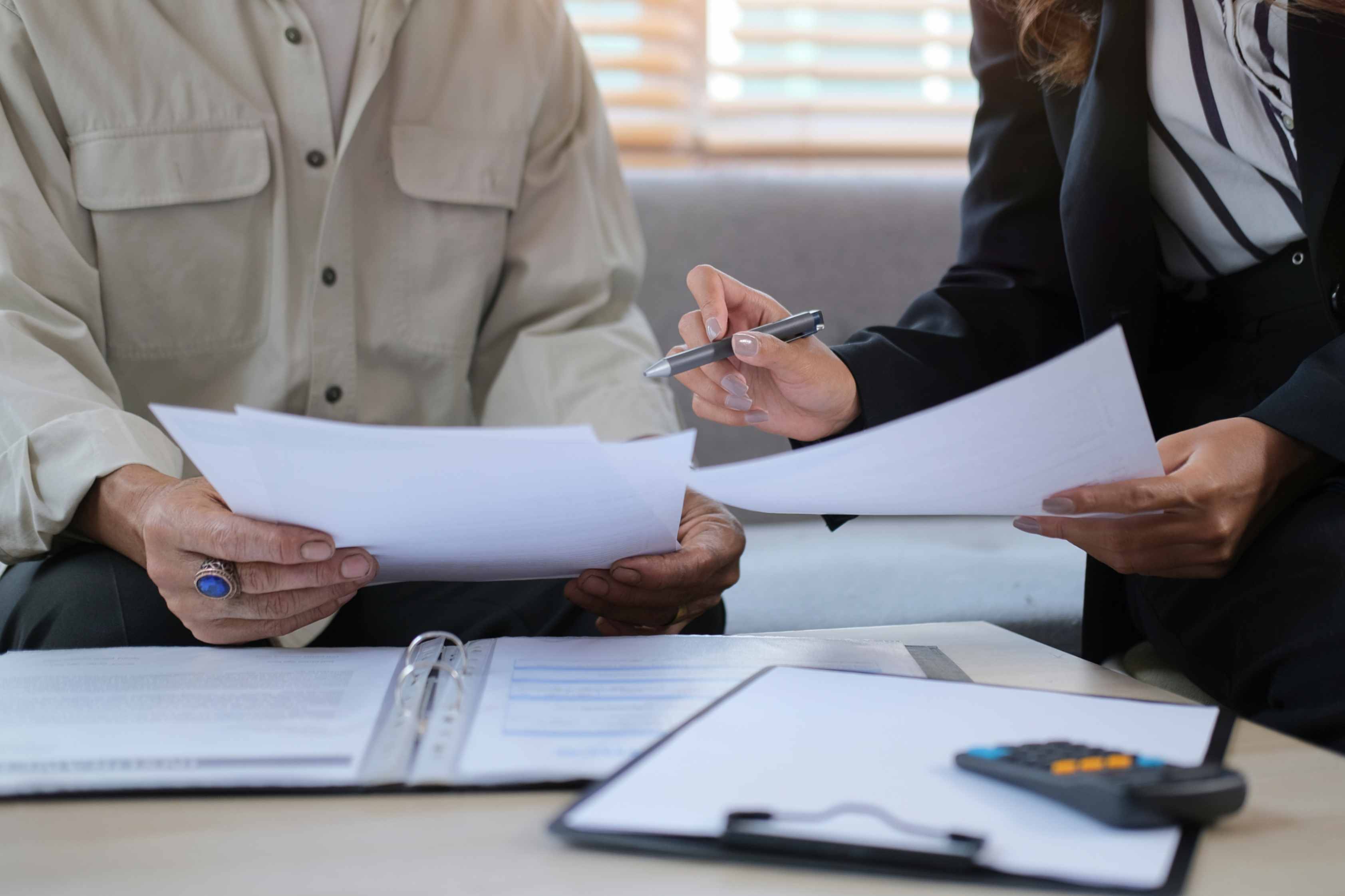 two people writing and looking over documents
