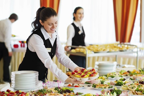 Hospitality workers plating a buffet table