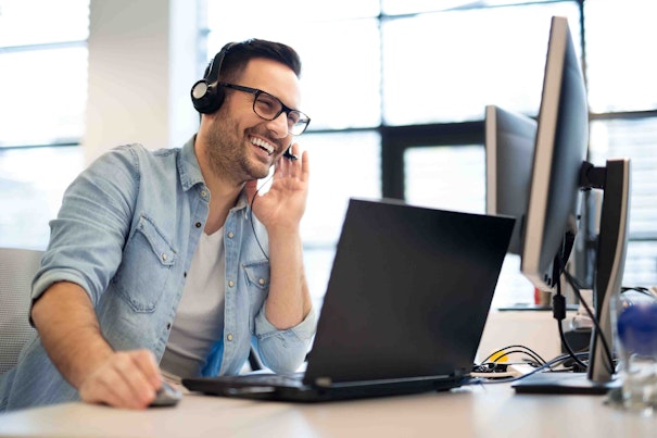 Male customer service representative smiling and talking on headset