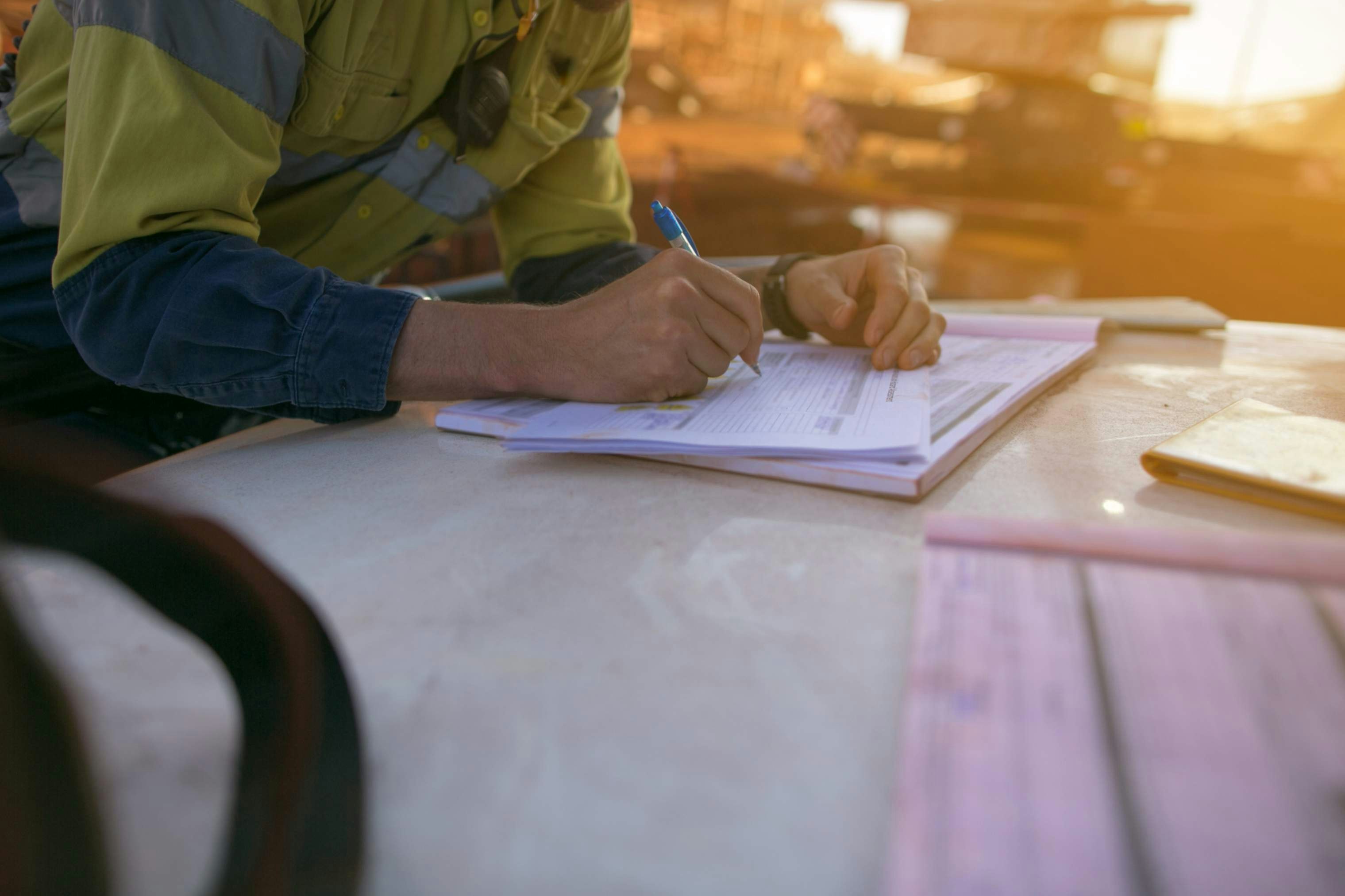 a person in high-vis writing on a notepad